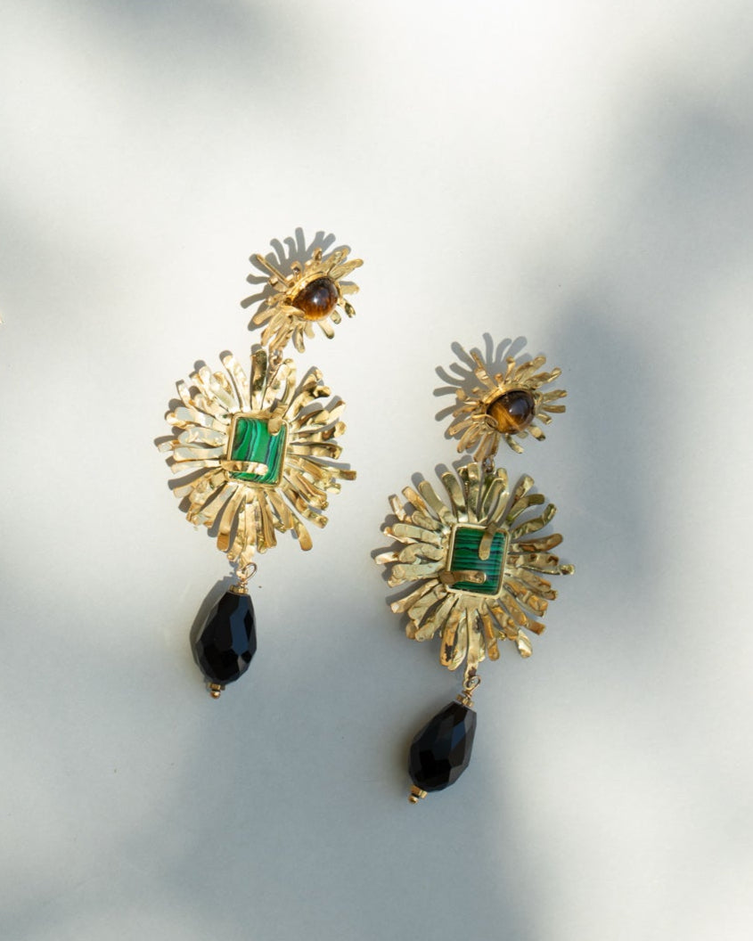 Gold earrings with gemstones on a light background