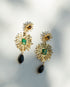 Gold earrings with gemstones on a light background