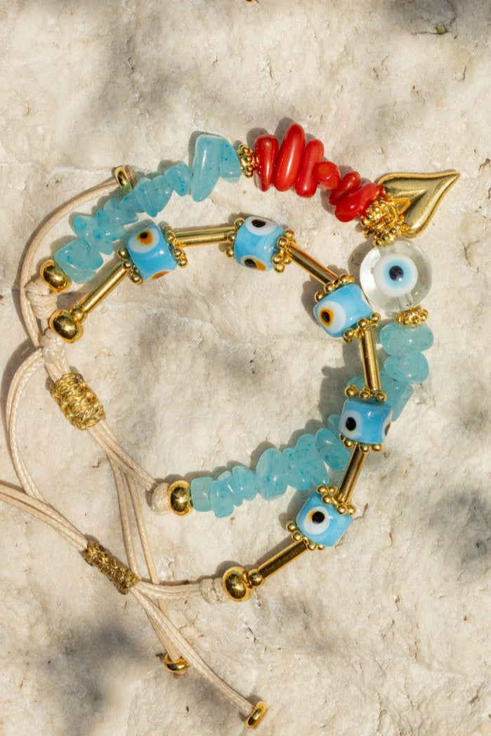 Jewelry set including earrings and bracelets on a textured surface